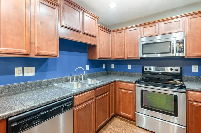 a kitchen with stainless steel appliances granite countertop a sink stove and microwave