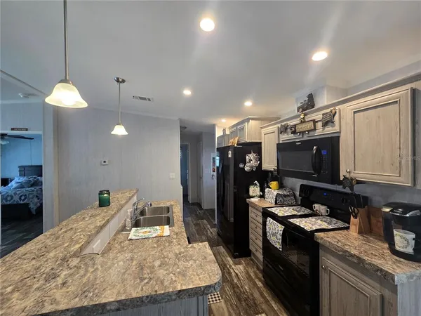a kitchen with stainless steel appliances granite countertop a sink stove and refrigerator
