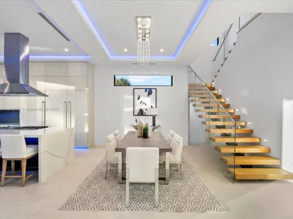 a kitchen with stainless steel appliances kitchen island granite countertop a table chairs in it and wooden floors