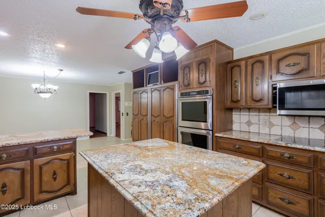 a kitchen with stainless steel appliances granite countertop stove top oven and cabinets