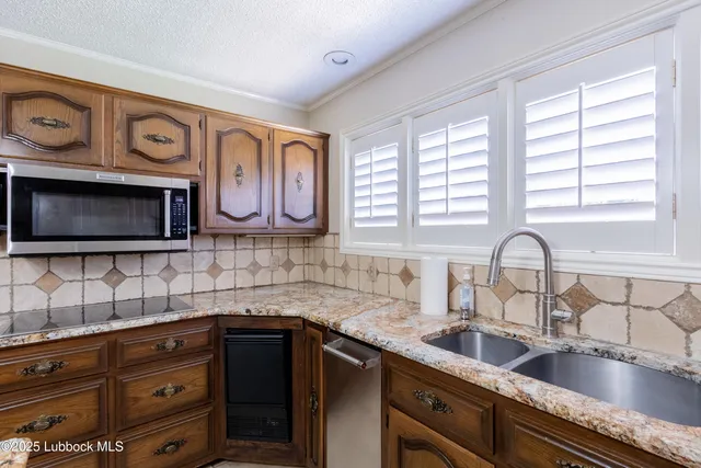 a view of an empty room with a chandelier fan and window