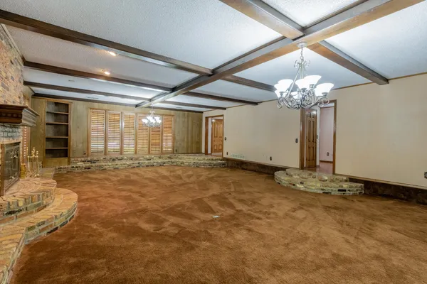 a spacious bedroom with a bed and a chandelier