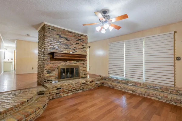 a view of a patio with table and chairs under an umbrella with a small yard