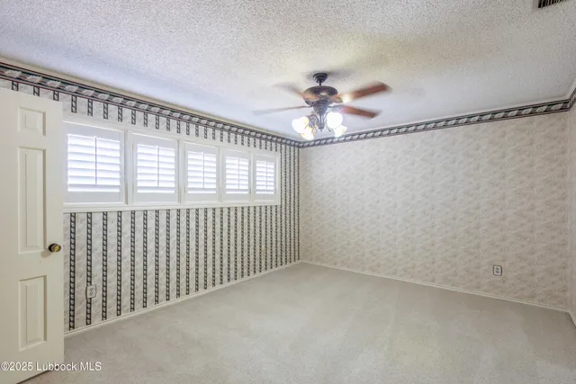 a view of a backyard with wooden fence and a large tree