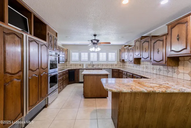 a large kitchen with stainless steel appliances granite countertop a stove a sink dishwasher and a refrigerator