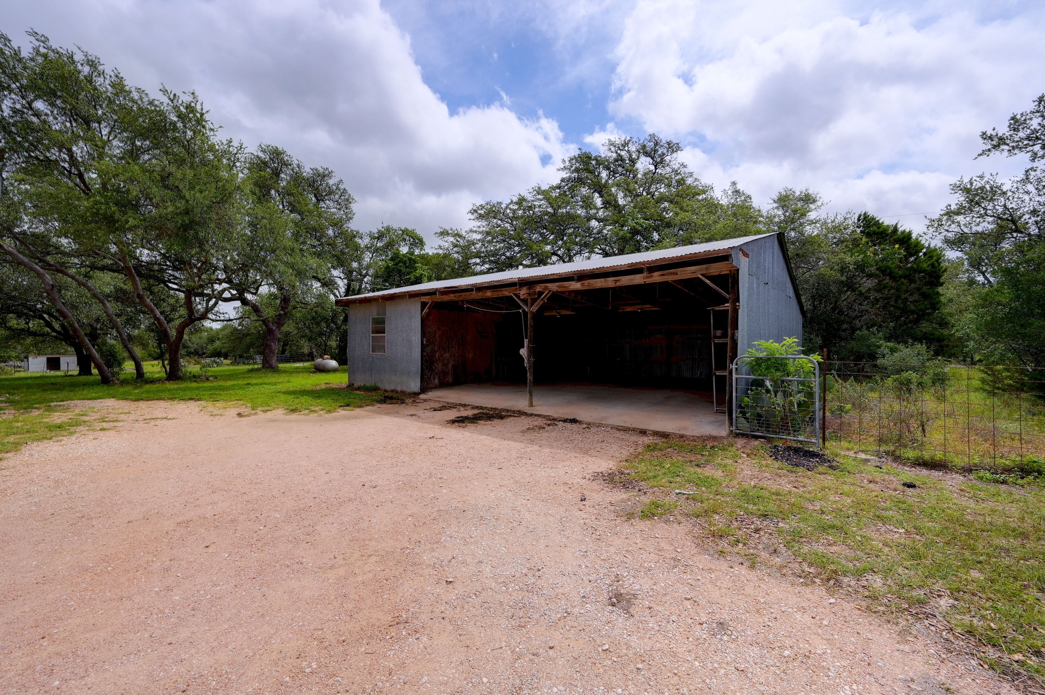 364 Nameless Road Driftwood, TX 78619 - Photo 30 of 32 A spacious, open pole barn structure provides ample utility space for various needs on this property. There is an enclosed storage space too.