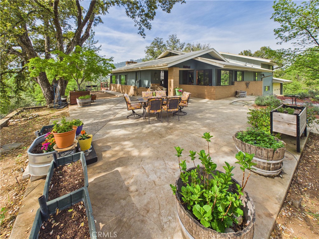 6650 Feliciana Mountain Road Midpines, CA 95345 - Photo 32 of 57 a view of a patio with table and chairs potted plants and large tree