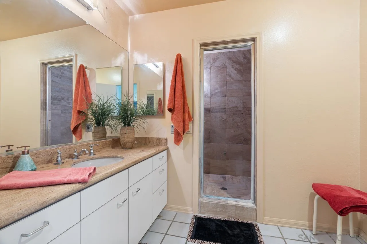 2626 Hidden Valley Road La Jolla, CA 92037 - Photo 16 of 54 a bathroom with a double vanity sink a toilet and a shower
