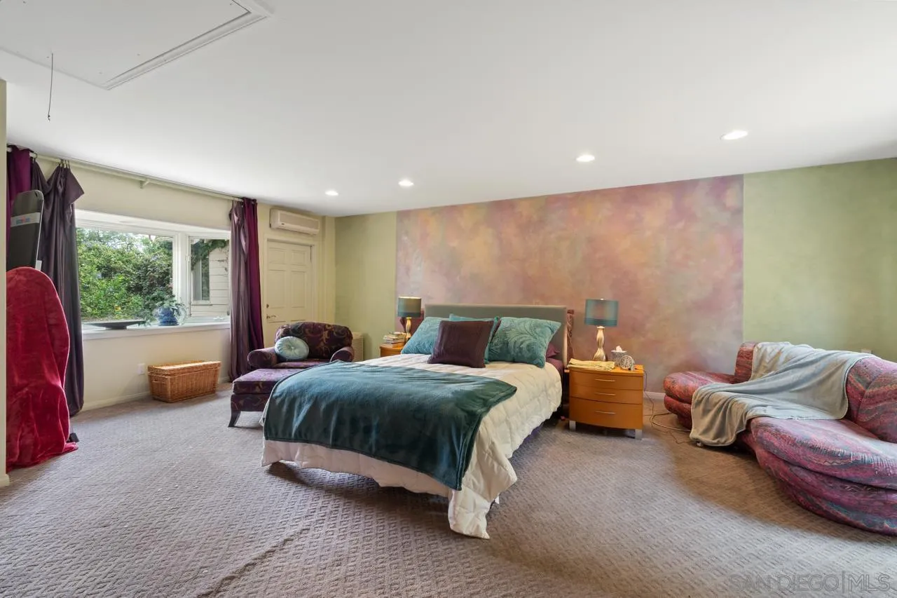 2626 Hidden Valley Road La Jolla, CA 92037 - Photo 19 of 54 a spacious bedroom with a bed and a couch