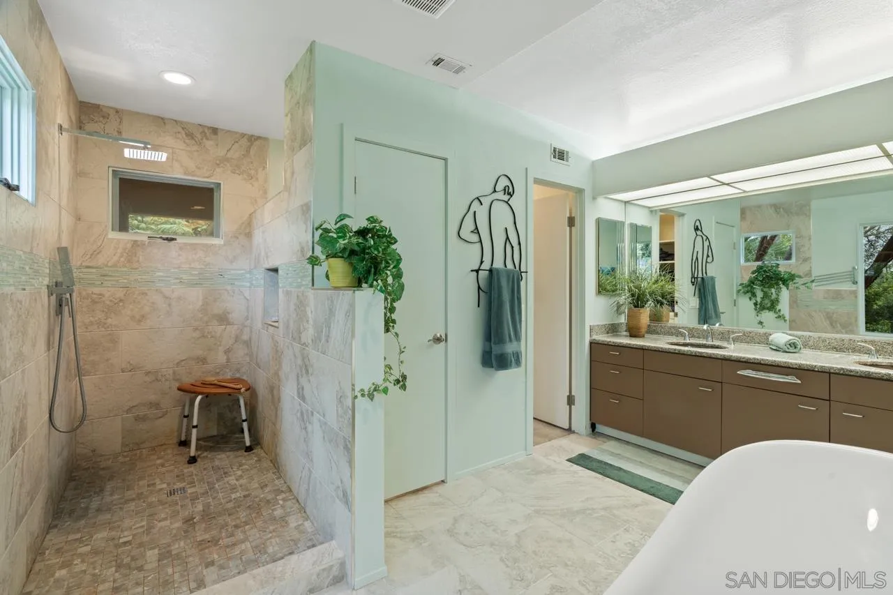2626 Hidden Valley Road La Jolla, CA 92037 - Photo 24 of 54 a bathroom with a granite countertop sink a toilet and shower