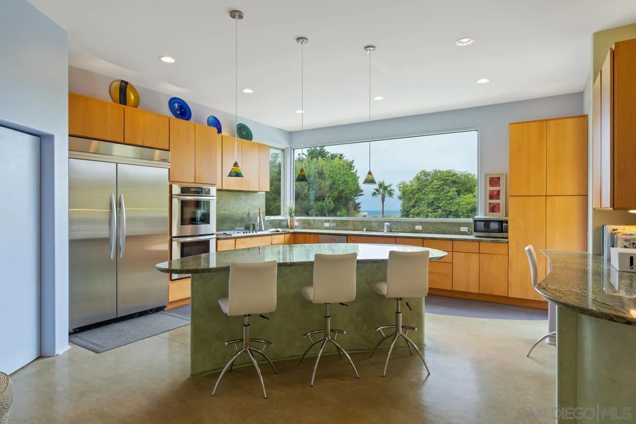 2626 Hidden Valley Road La Jolla, CA 92037 - Photo 36 of 54 a kitchen with stainless steel appliances granite countertop a refrigerator a sink a stove and white cabinets with wooden floor