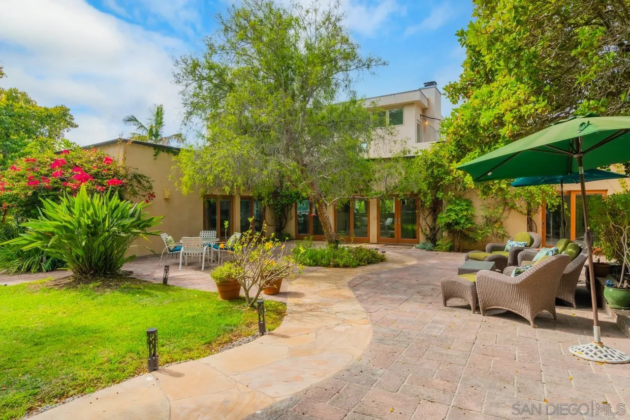 2626 Hidden Valley Road La Jolla, CA 92037 - Photo 9 of 54 a view of a patio with table and chairs under an umbrella