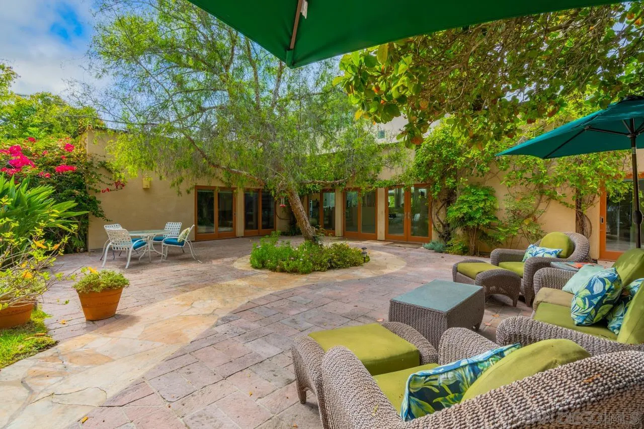 2626 Hidden Valley Road La Jolla, CA 92037 - Photo 10 of 54 a view of a patio with couches and chairs under an umbrella