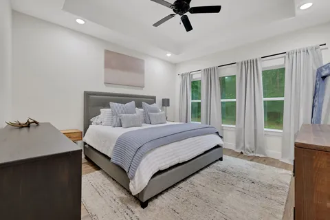 a bedroom with a bed and large windows