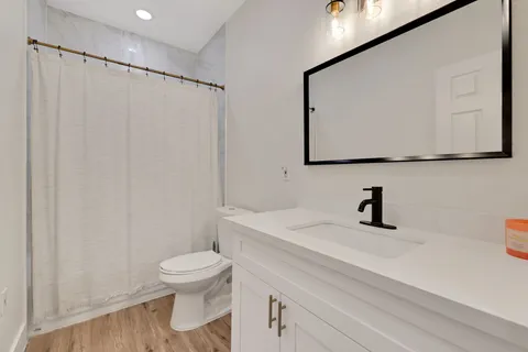 a bathroom with a sink a toilet and mirror