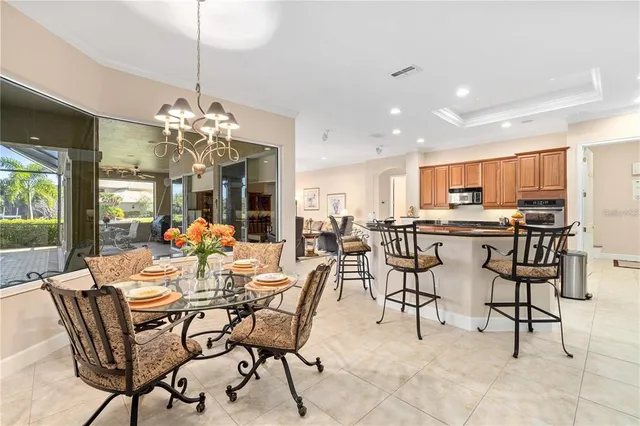 a kitchen with stainless steel appliances granite countertop a stove top oven a sink dishwasher a dining table and chairs with wooden floor