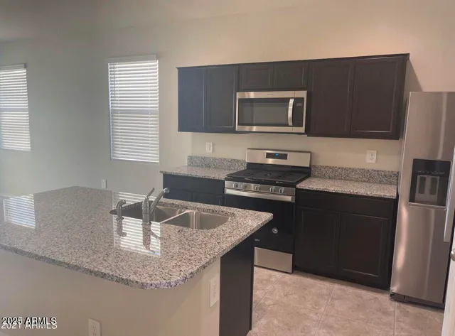 a kitchen with granite countertop a sink and a stove top oven with wooden floor