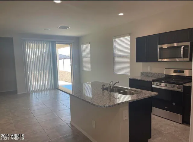 a kitchen with stainless steel appliances granite countertop a sink stove and microwave