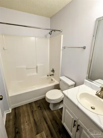 a bathroom with a sink a toilet a mirror and shower