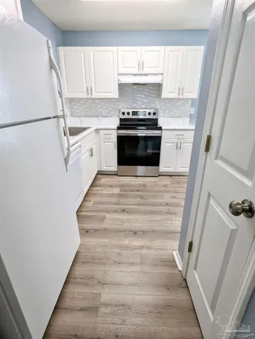a kitchen with stainless steel appliances a refrigerator sink and cabinets