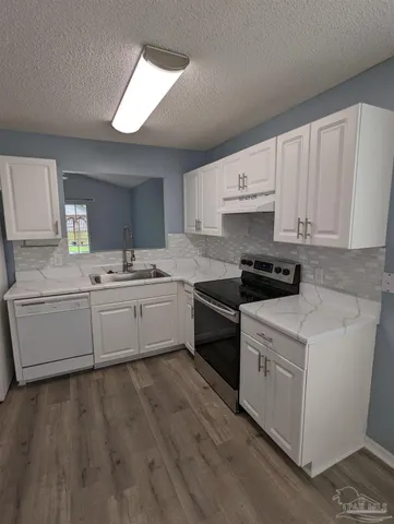 a kitchen with a white cabinets and window