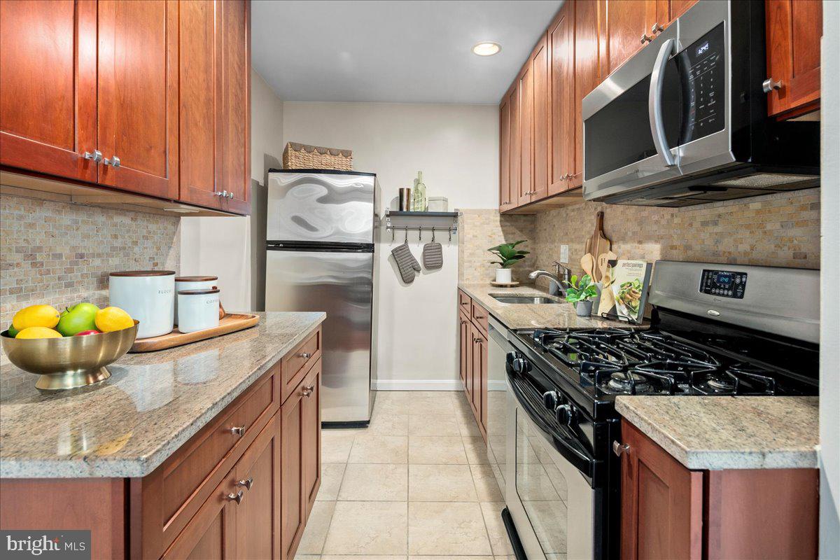 2016 North Adams Street, Unit 701 Arlington, VA 22201 - Photo 12 of 32 a kitchen with granite countertop a sink stove and cabinets