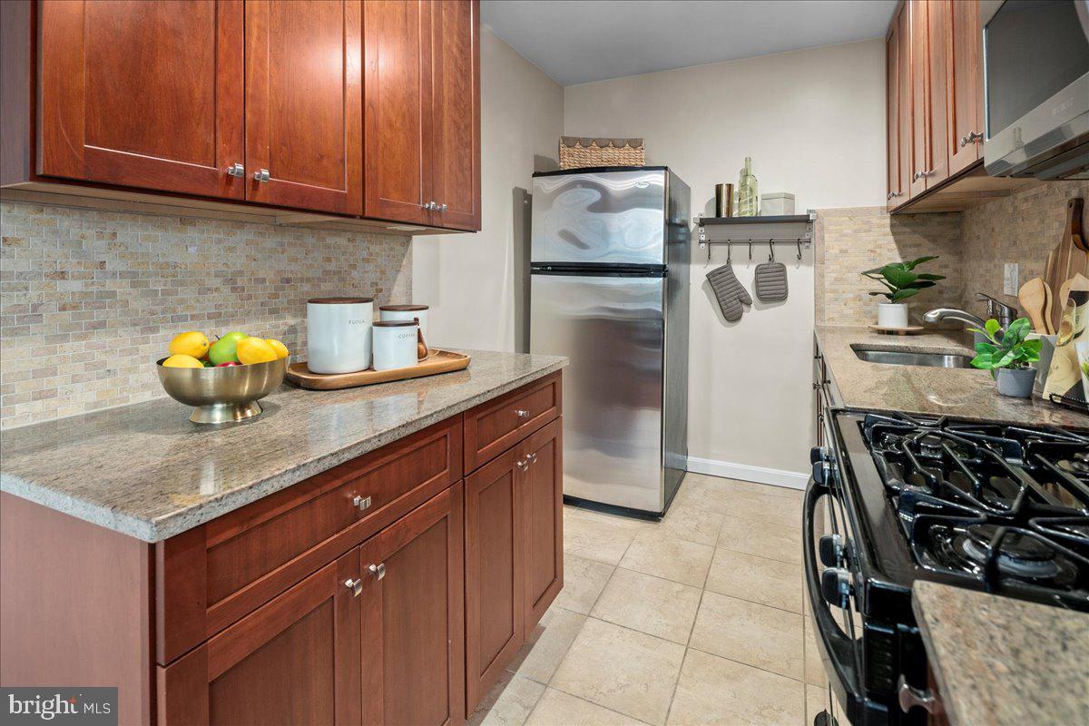 2016 North Adams Street, Unit 701 Arlington, VA 22201 - Photo 13 of 32 a kitchen with stainless steel appliances granite countertop a sink stove and refrigerator