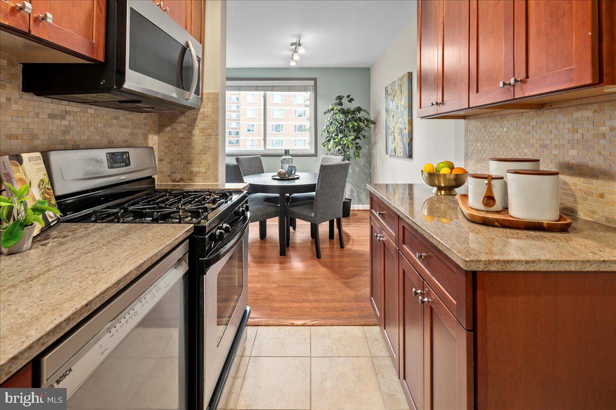 2016 North Adams Street, Unit 701 Arlington, VA 22201 - Photo 14 of 32 a kitchen with granite countertop stainless steel appliances and wooden cabinets