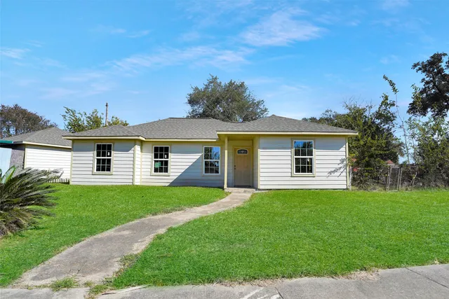 a front view of a house with a garden and yard