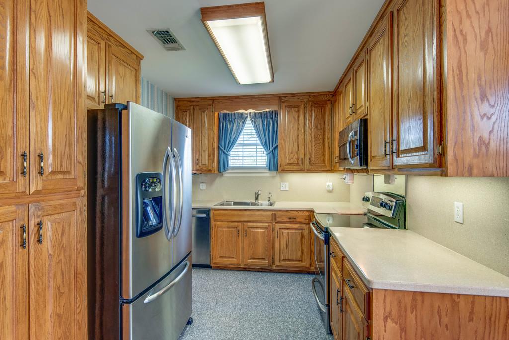 700 General George Patton Road Nashville, TN 37221 - Photo 3 of 21 a kitchen with a sink a refrigerator and cabinets