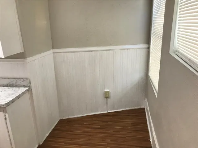 a view of a storage and utility room with wooden floor