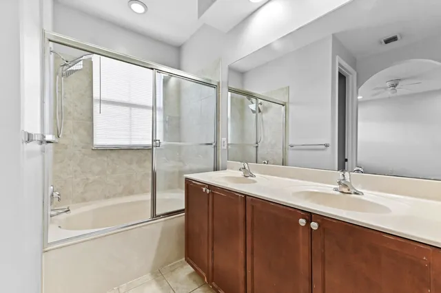 a bathroom with a double vanity sink mirror and shower