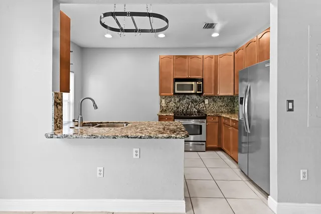 a kitchen with stainless steel appliances granite countertop a sink and cabinets