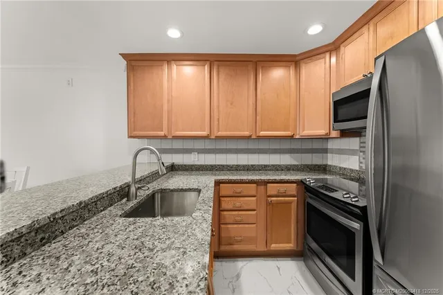a kitchen with granite countertop a sink and a stove