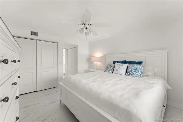 a bedroom with a large bed and a chandelier