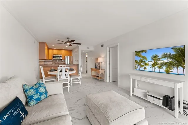 a kitchen with stainless steel appliances a dining table chairs and white cabinets