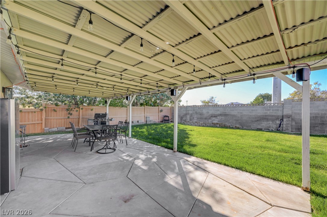 1331 Pinto Road Boulder City, NV 89005 - Photo 33 of 46 A private backyard oasis featuring a spacious patio under a covered pergola and a well-maintained lawn.