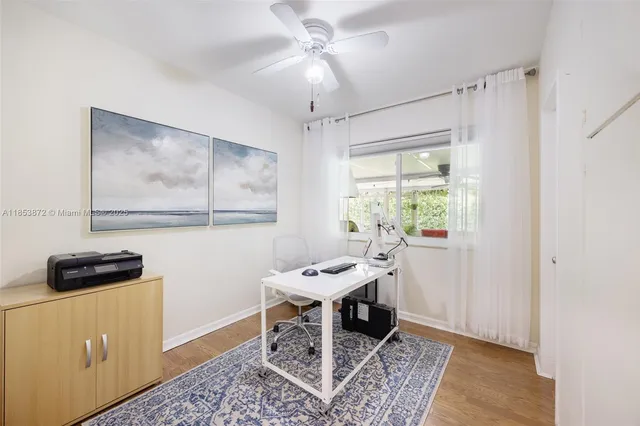 a view of a workspace with furniture and a window
