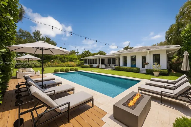 a view of a swimming pool with lounge chairs in the patio