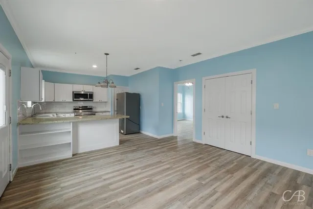 a view of kitchen with wooden floor and electronic appliances