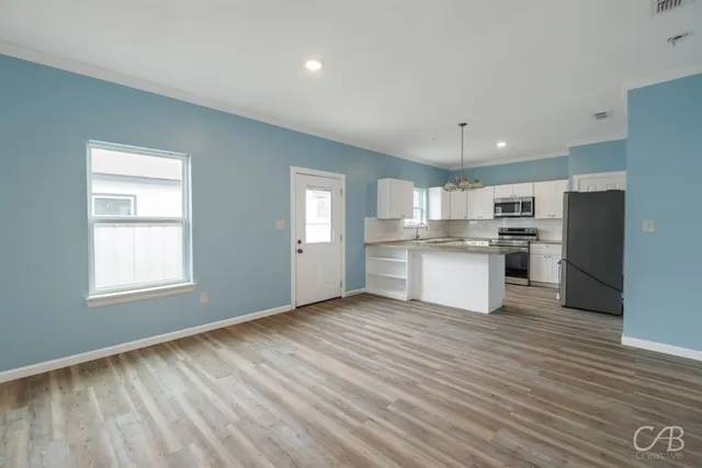 a view of kitchen with wooden floor and electronic appliances