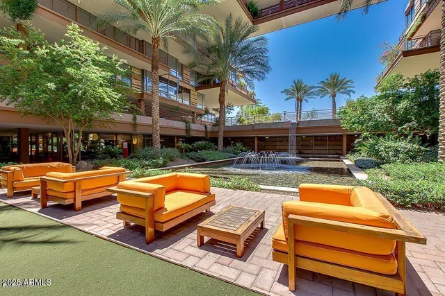 an outdoor sitting area with swimming pool table and chairs