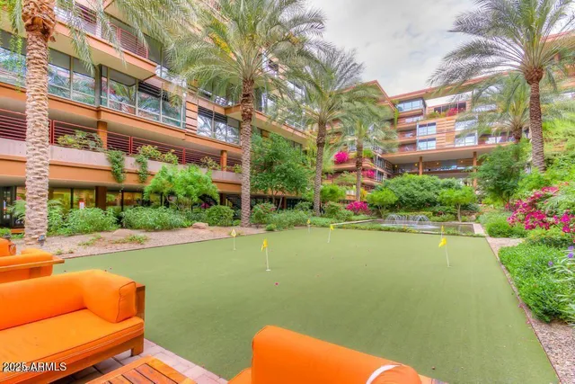 a front view of building and lake with seating space