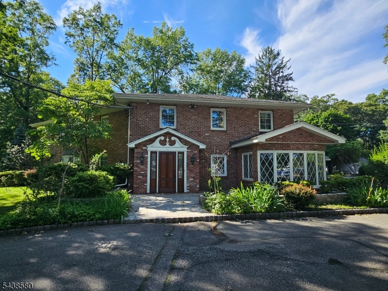 a front view of a house with plants and trees