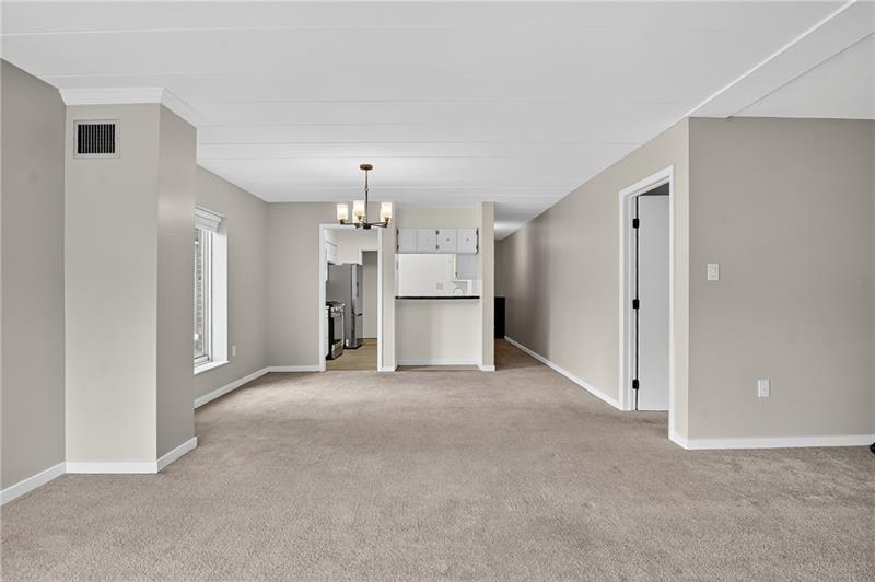 5 Bayard Road, Unit 500 Pittsburgh, PA 15213 - Photo 11 of 20 an empty room with a kitchen and a refrigerator
