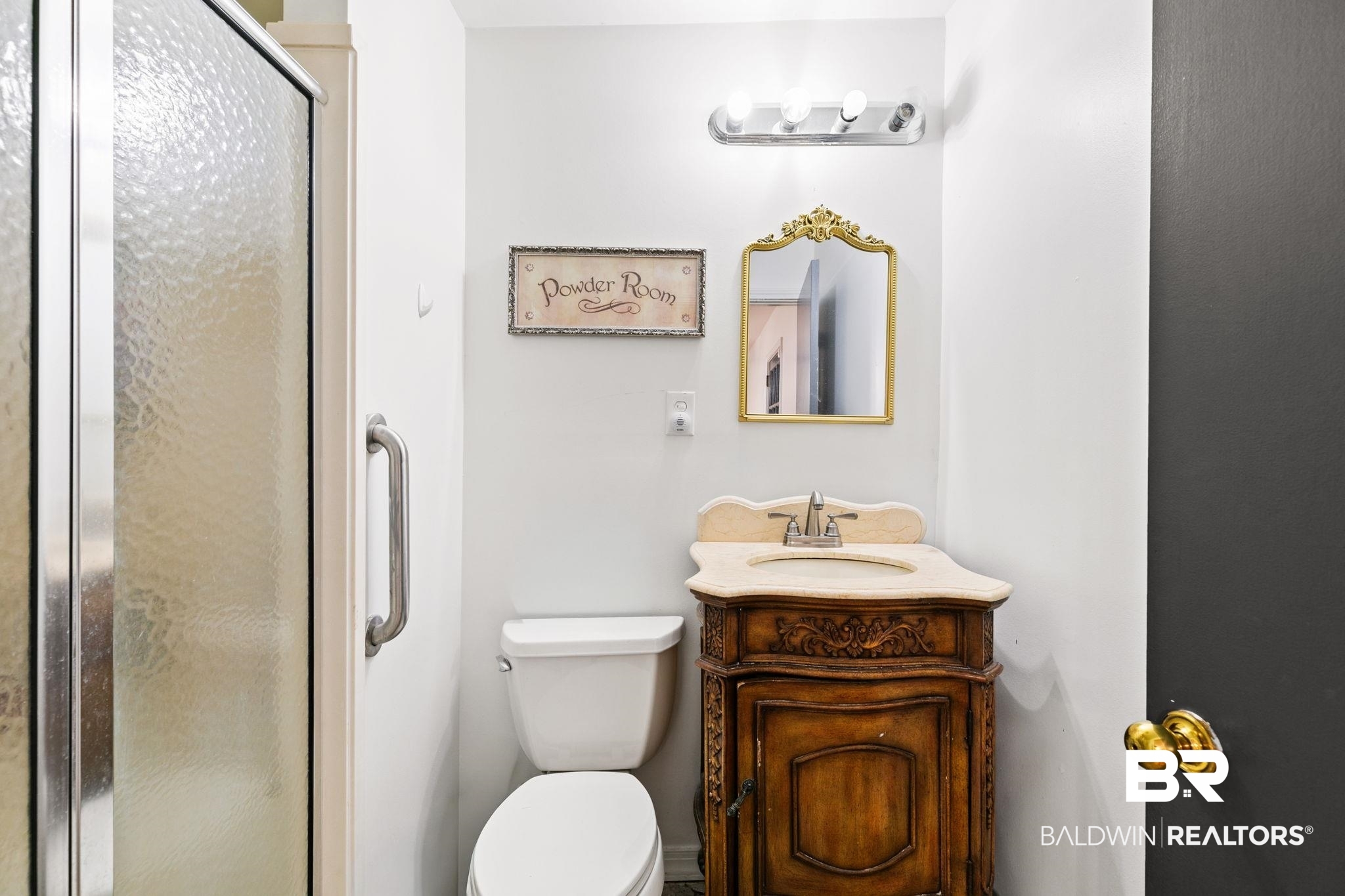 927 Cleveland Road Saraland, AL 36571 - Photo 25 of 80 Bathroom featuring a glass-enclosed shower, a white toilet, and a carved wood vanity with a light-colored countertop