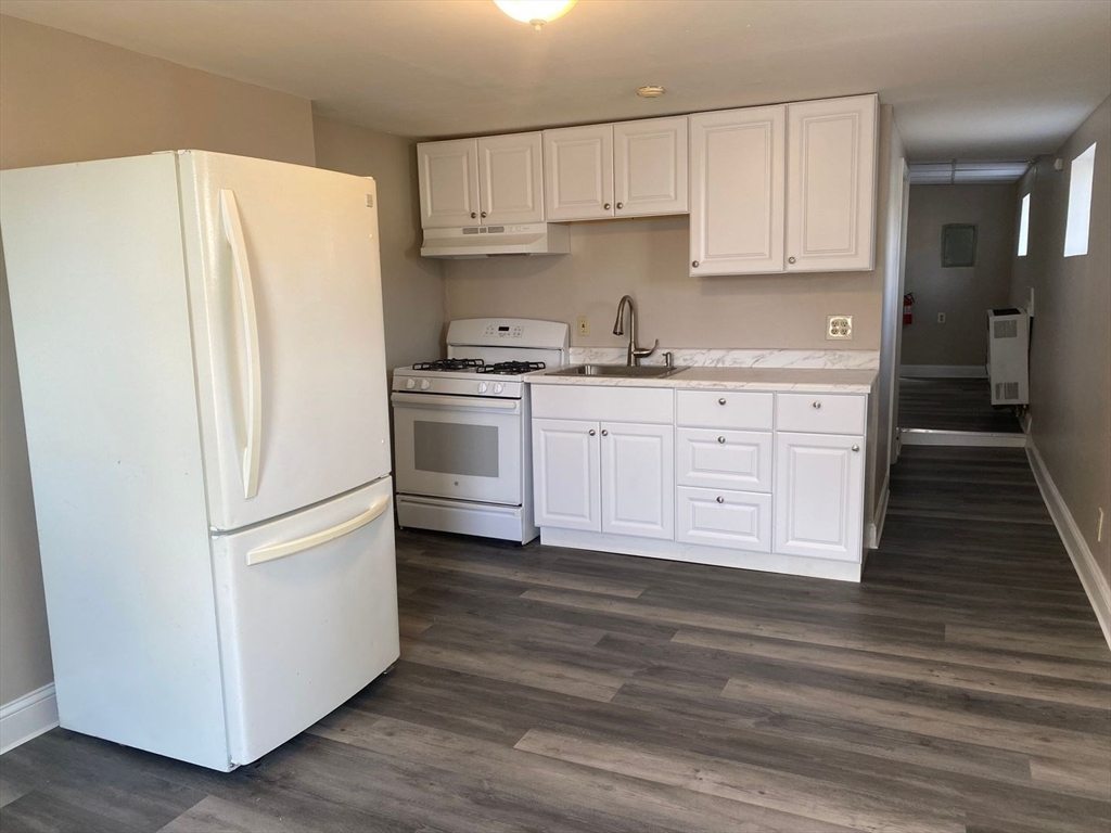 99 Mammoth Road, Unit 1 Lowell, MA 01854 - Photo 1 of 6 a kitchen with stainless steel appliances a refrigerator sink and cabinets