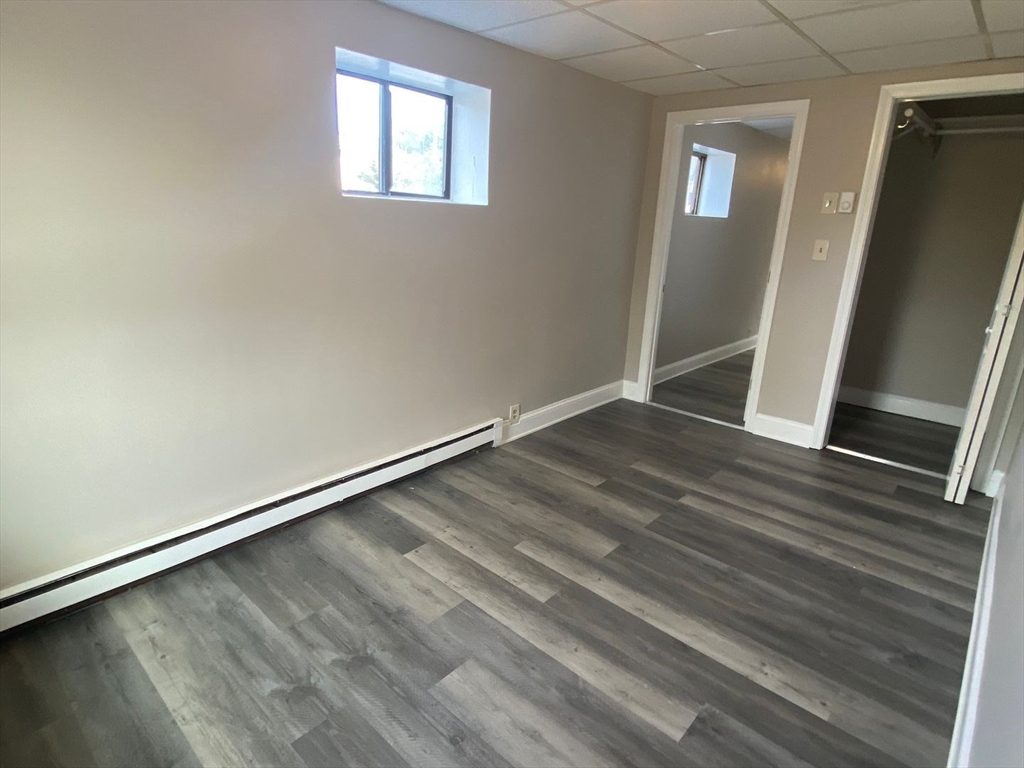 99 Mammoth Road, Unit 1 Lowell, MA 01854 - Photo 2 of 6 an empty room with wooden floor and windows