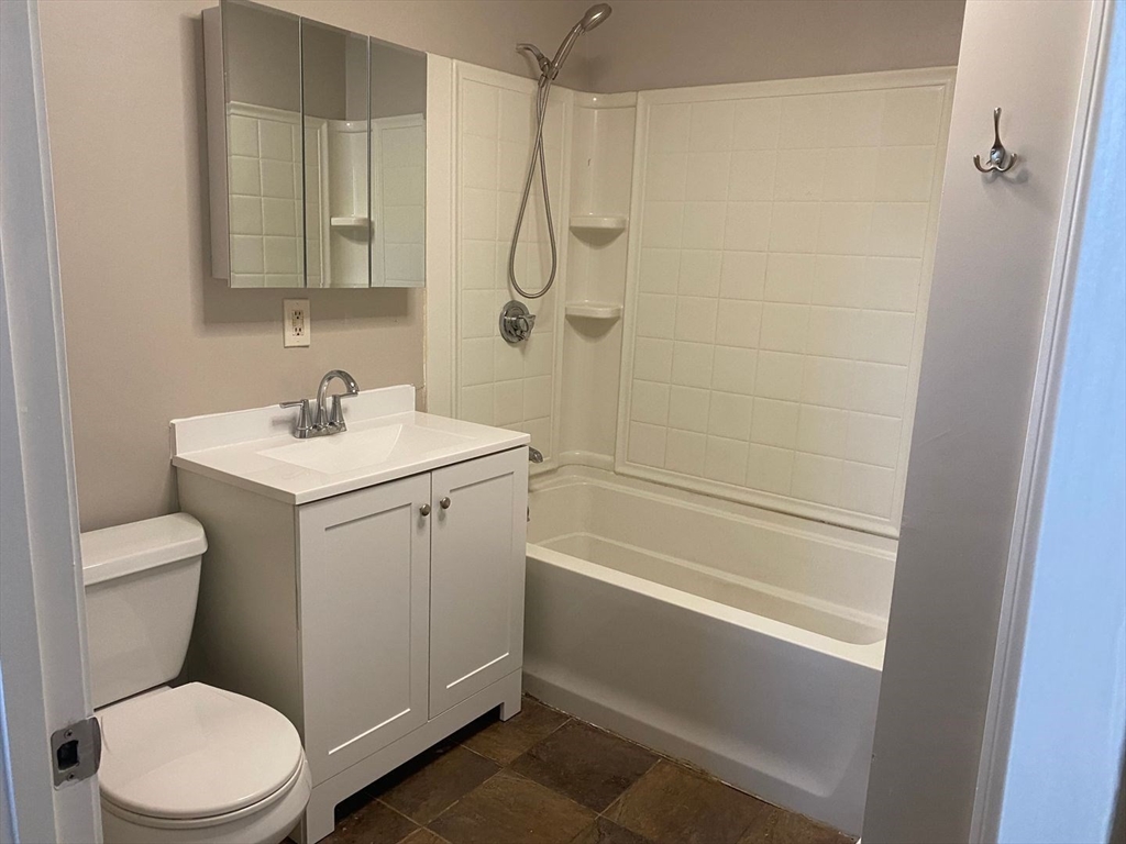 99 Mammoth Road, Unit 1 Lowell, MA 01854 - Photo 3 of 6 a bathroom with a sink a toilet and shower