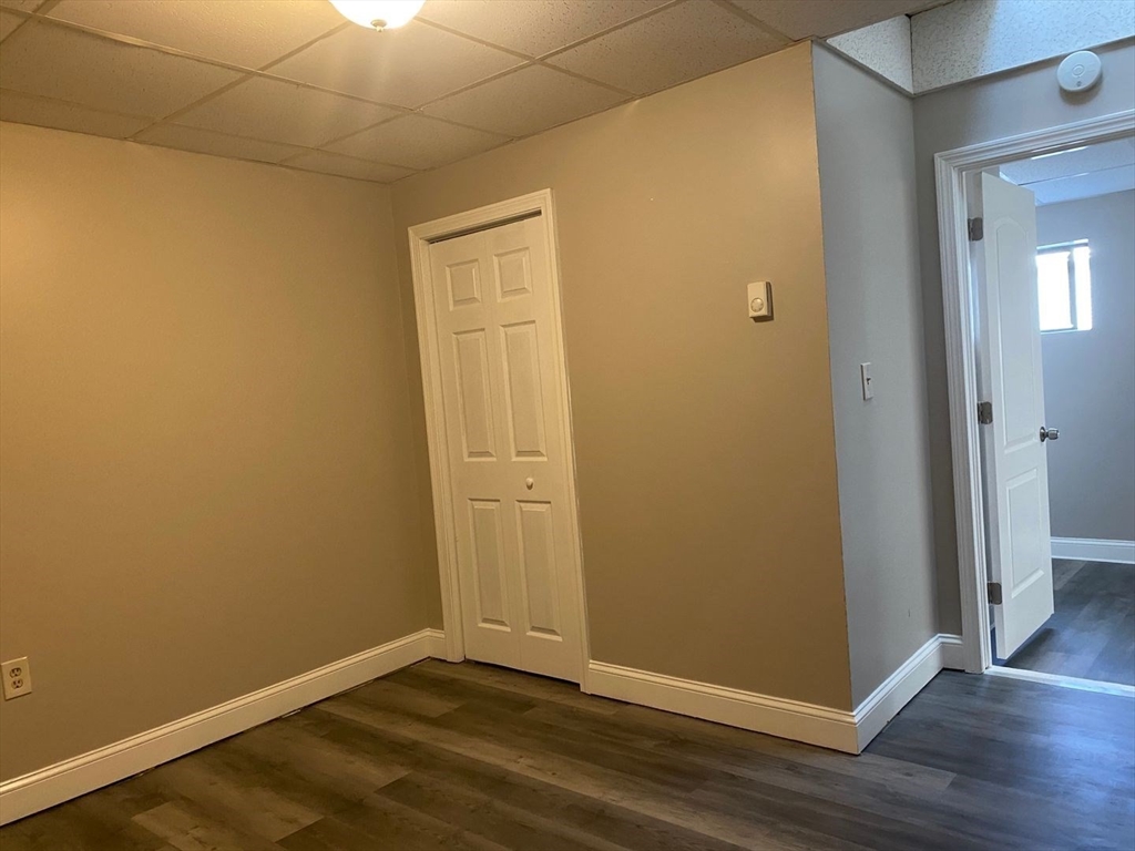 99 Mammoth Road, Unit 1 Lowell, MA 01854 - Photo 5 of 6 an empty room with wooden floor and closet